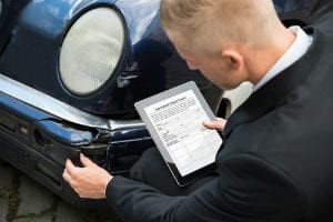 Insurance adjuster inspecting a car involved in an accident