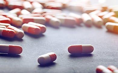 medical prescription pills scattered on top of a table