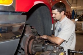 Mechanic checks tractor trailer truck brakes after New Jersey truck accident.