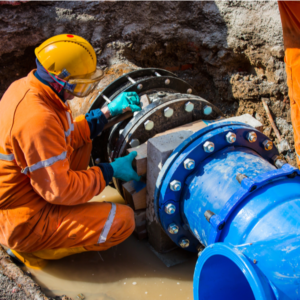 a worker fixing an old big drink water pipes