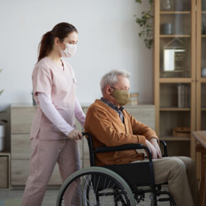 young female nurse taking care of an old man