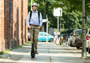man riding an e-scooter on his way to work in NJ