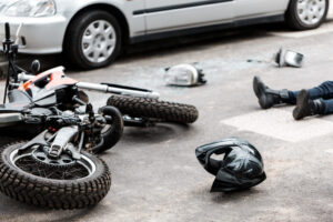 scene of a motorcycle accident in pennington, NJ where motorcycle is laying on the ground beside helmet and injured motorcycle rider