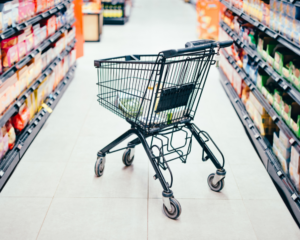 a shopping cart in the aisle of a supermarket